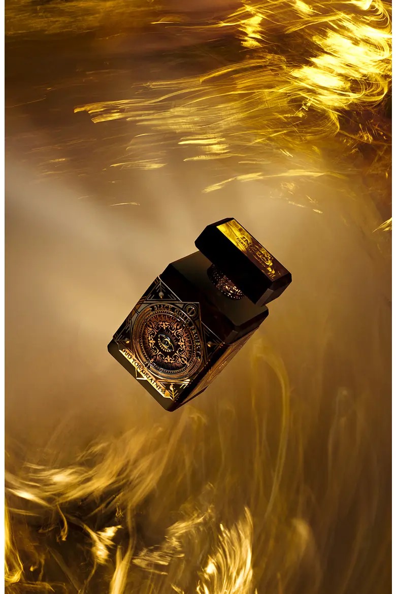 Initio Oud For Greatness fragrance bottle in golden light