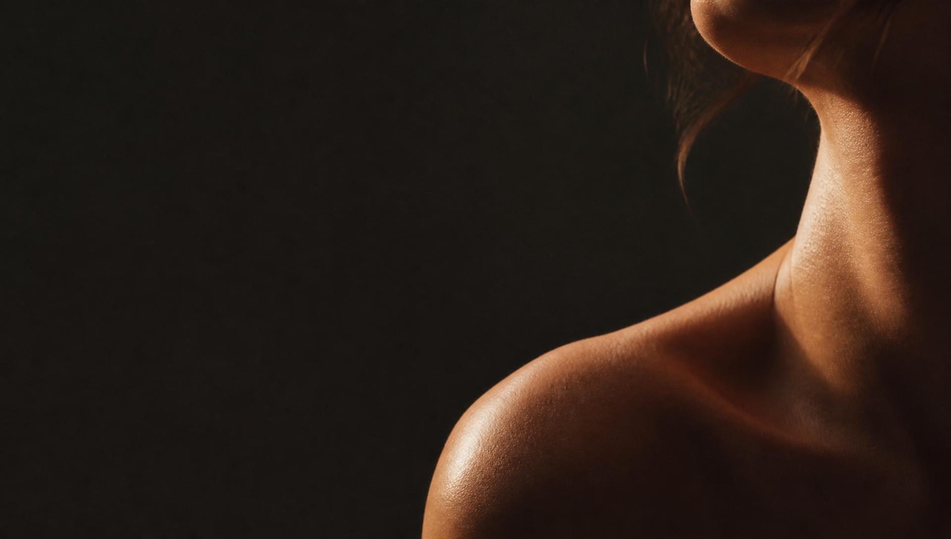 Close editorial crop of a shoulder and neck in warm raking light